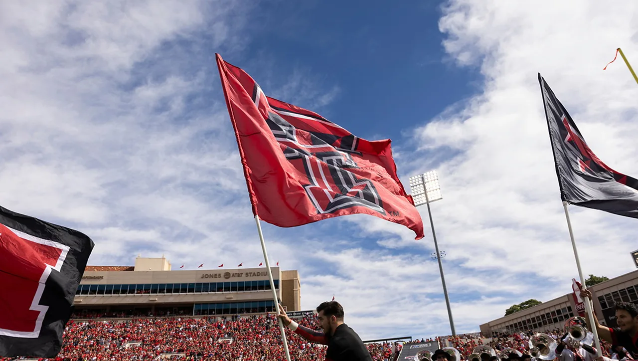 A Texas Tech flag waving above the crowd at a football game